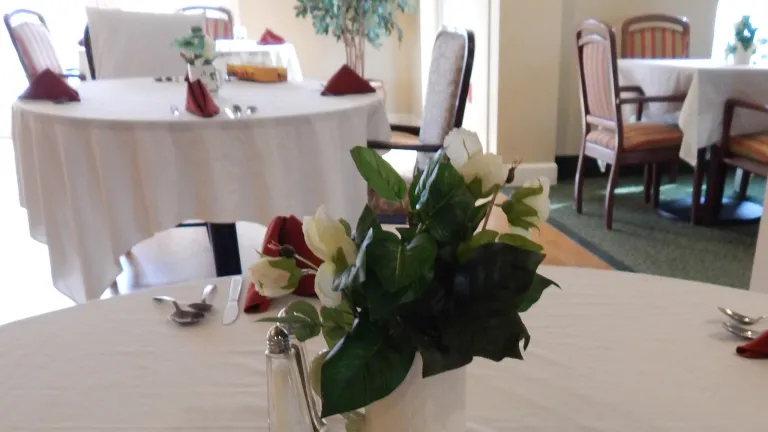 Courtyard Eatery tables with white linen tablecloths and floral centerpieces