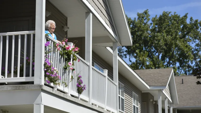 Woman standing on her balcony with flowers