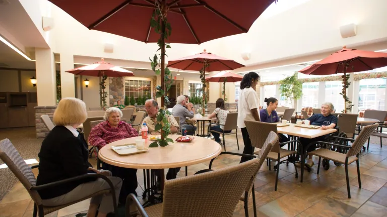 Residents, family members, and staff dining and chatting in the Town Square