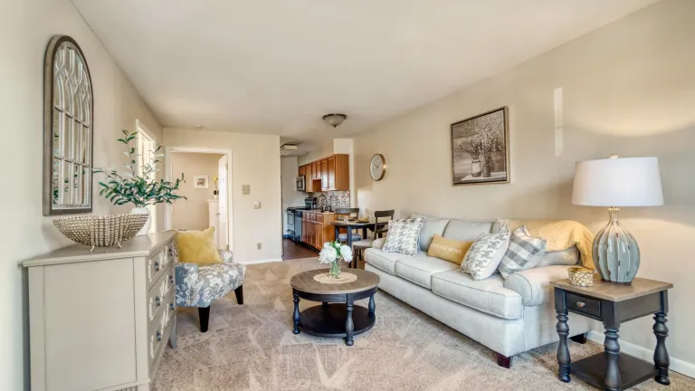 A beige living room with gray and yellow furniture