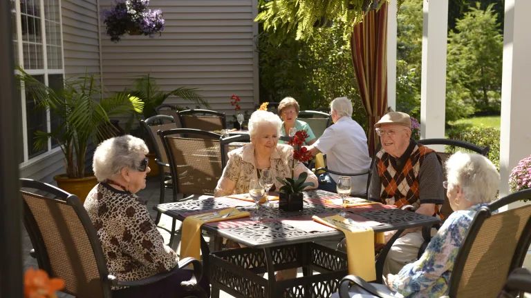 Residents enjoying a meal on an outdoor dining patio