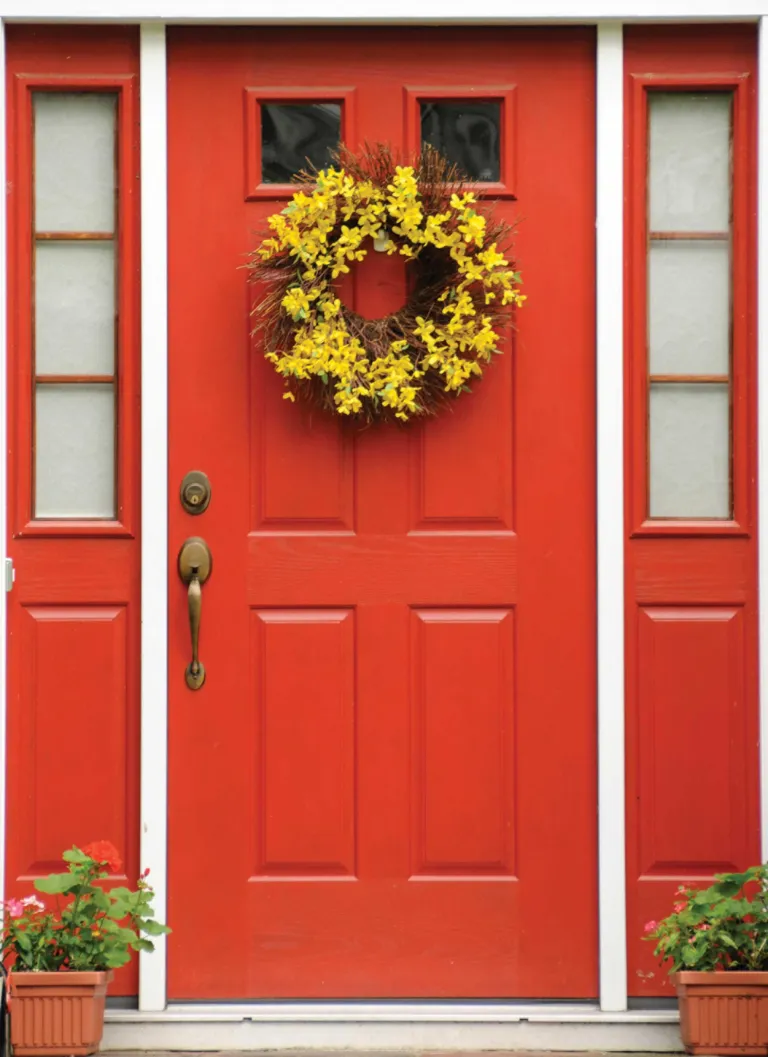An image of a bright red door with a yellow wreath 
