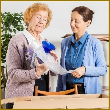 Older woman examines home good items with aide