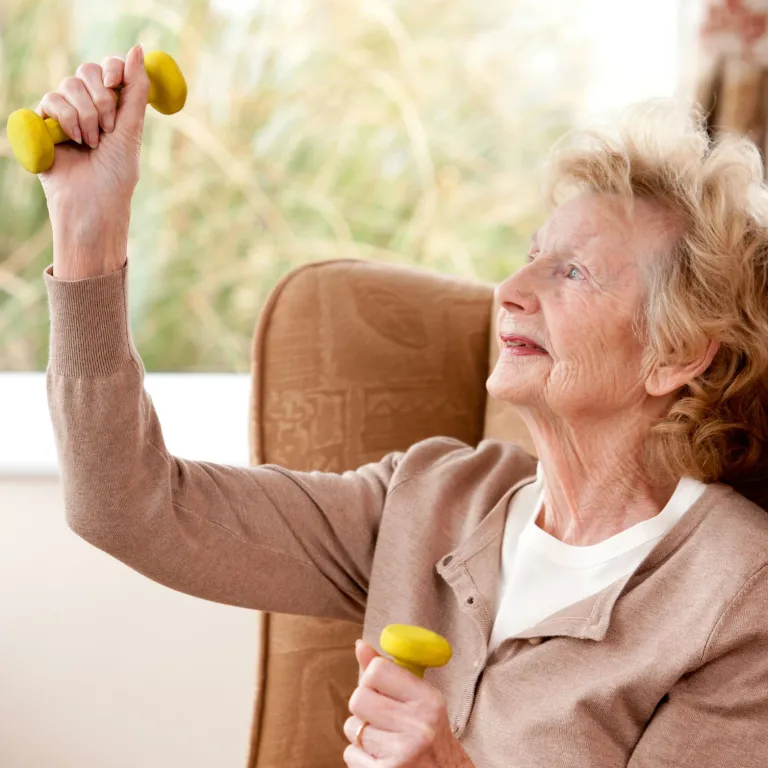 Senior resident exercising with arm weights