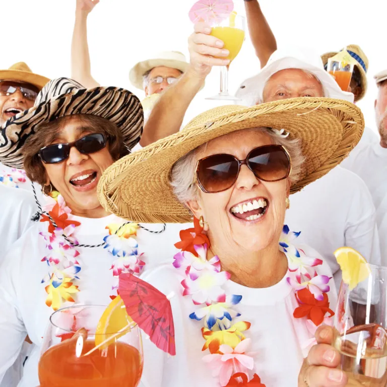 Group of women smiling outside wearing hats and leis