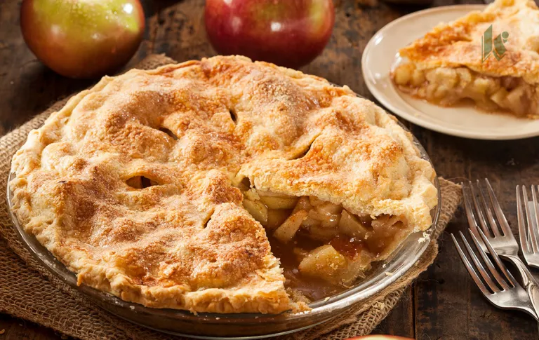 An apple pie in a dish with a slice cut out of it