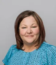 Vicki Avery headshot, she has shoulder length brown hair and is wearing a light blue blouse with black polka dots.