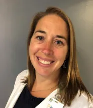 Kristin Reade headshot, she is seen in her lab jacket with a black blouse and name tag