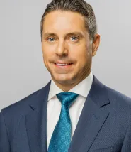 Headshot for Michael McParlton, he is wearing a navy blue suit with a blue tie and white dress shirt.